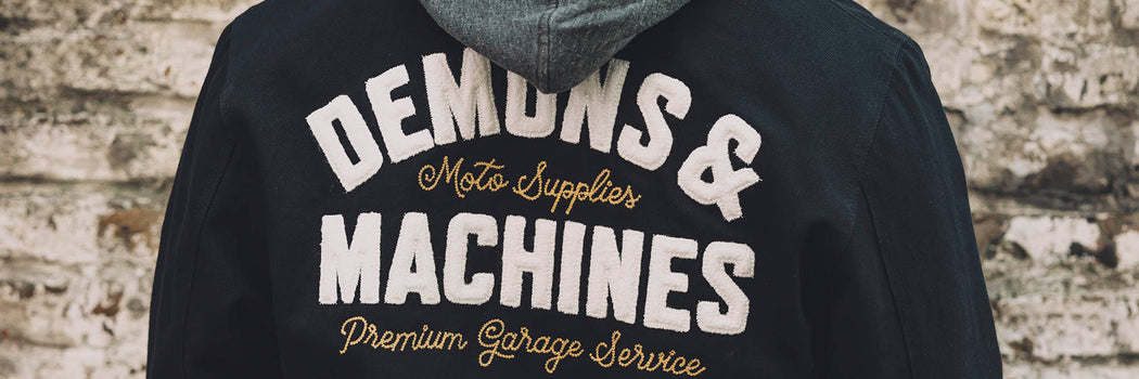 ESPALDA DE BUZO NEGRO DEMONS & MACHINES CON TIPOGRAFÍA VINTAGE “MOTO SUPPLIES / PREMIUM GARAGE SERVICE”