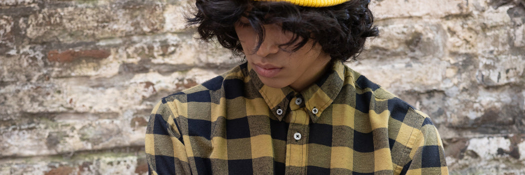 CAMISA CUADROS AMARILLA Y NEGRA ESTILO WORKWEAR CON GORRO TEJIDO SOBRE FONDO DE LADRILLO