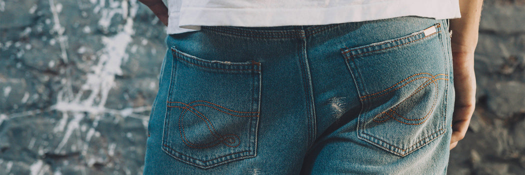 DETALLE TRASERO DE JEAN DENIM CON DESGASTE Y COSTURAS CUSTOM EN BOLSILLOS