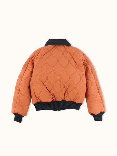 Campera Demons & Machines reversible estilo aviadora. Este estilo remite al modelo de camperas ALPHA, icónicas de la Fuerza Aérea por su diseño funcional para pilotos, caracterizadas por materiales resistentes, puños tejidos, bolsillos utilitarios y reversibilidad naranja para visibilidad en emergencias.