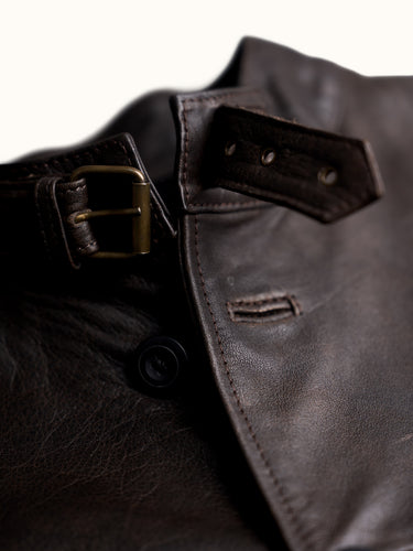 Campera de Demons & Machines confeccionada en cuero vacuno gastado. Calce regular, cuello alto con presilla de ajuste mediante hebilla metálica, acceso con botones pasta negros y ojales sastreros. El corte y confección de cada una de nuestras camperas de cuero se lleva a cabo de manera artesanal y personalizada.