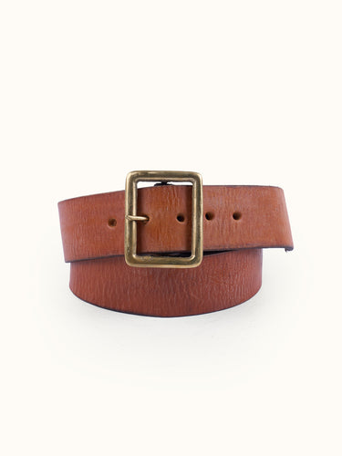 Cinturón modelo clásico confeccionado artesanalmente en cuero vacuno con terminación envejecida. Hebilla rectangular metálica grande en baño oro italiano y remaches baño cobre con refuerzo de cuero. Logo de marca grabado en bajo relieve. Forma parte de nuestra línea artesanal de accesorios de edición limitada, donde ningún producto es exactamente igual al otro. #color_marr-n