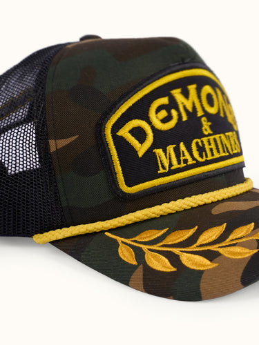 Gorra Podium de Demon & Machines con diseño camuflaje, vista frontal de la gorra con bordado en el frente.