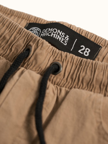 Pantalón Demons & Machines de corte jogger slim, confeccionado en gabardina elastizada. Bolsillos delanteros y bolsillo relojero bien jeaneros, cintura con elástico interno y cordón ajustable, bolsillos plaqué en trasero. #color_camel