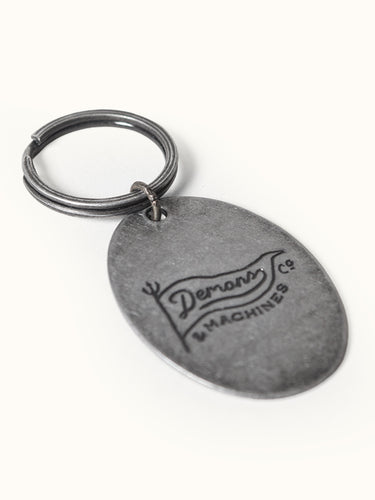 Llavero Hana de Demons & Machines con diseño detallado en metal, ideal para llaves y accesorios.
