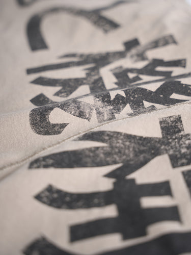 Remera Relax Kanji khaki, detalle de la estampa en kanji con efecto gastado. #color_khaki