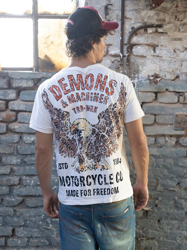 Remera slim DEMONS & MACHINES con diseño de águila en el frente, camiseta ajustada para mujer, estilo moderno y casual. #color_crudo