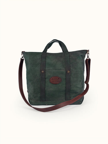 Bolso Campville verde de frente con bolsillo, parche de cuero ovalado y correa de cuero cruzada #color_verde