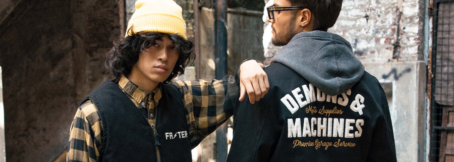 Modelos vistiendo prendas Demons & Machines en estética urbana, con campera con logo trasero y look workwear contemporáneo