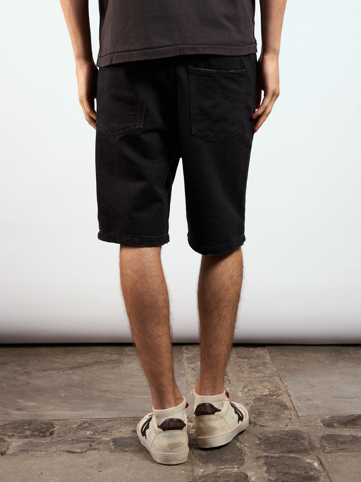 Bermuda Alex Black puesta, vista de frente con remera negra y zapatillas crudas #color_negro