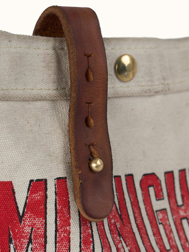 Inspirado en las primeras bolsas usadas para el reparto de periódicos, nuestro Bolso Newspaper puede usarse sobre el hombro o cruzado. Confeccionado artesanalmente en lona pesada de algodón, con broches snap metálicos, presillas en cuero vacuno con tratamiento envejecido y correa ancha de algodón reforzada con múltiples pespuntes. Cuenta con bolsillo interno. Arte de marca de estética vintage estampado en serigrafía.