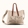 Bolso Demons & Machines estilo tote confeccionado artesanalmente en lona pesada de algodón, con manija en cuero vacuno 100% y correa reforzada de algodón regulable. Herrajes metálicos en baño cobre empavonado oxidados artesanalmente. Cuenta con dos bolsillos internos. Logo de marca estampado en serigrafía con efecto gastado y roto.