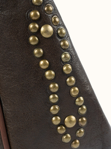 Detalle de la hilera de tachas de bronce en el lateral de cuero marrón del Bolso Messenger #color_marron