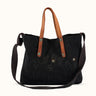 Bolso Demons & Machines estilo tote confeccionado artesanalmente en lona pesada de algodón, con manija en cuero vacuno 100% y correa reforzada de algodón regulable. Herrajes metálicos en baño cobre empavonado oxidados artesanalmente. Cuenta con dos bolsillos internos. Logo de marca estampado en serigrafía con efecto gastado y roto. #color_negro