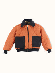 Campera Demons & Machines reversible estilo aviadora. Este estilo remite al modelo de camperas ALPHA, icónicas de la Fuerza Aérea por su diseño funcional para pilotos, caracterizadas por materiales resistentes, puños tejidos, bolsillos utilitarios y reversibilidad naranja para visibilidad en emergencias.
