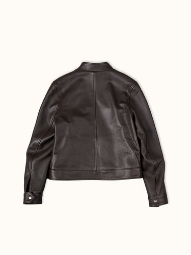 Campera de de Demons & Machines confeccionada en cuero vacuno graneado. Cuello mao, largo a la cintura y acceso con cierre metal plata vieja cadena 8. Bolsillos superiores con cierre y bolsillos inferiores con tapa y broche suizo. Puños con broche suizo plata vieja.