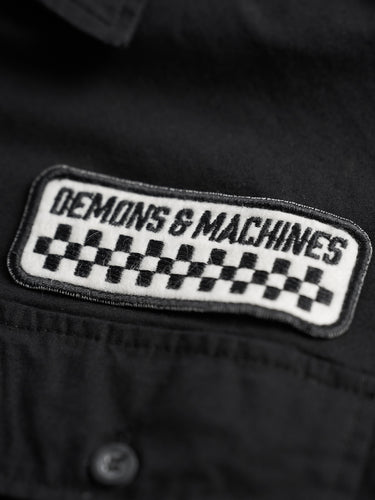 Camisa Garage Russel negra, detalle del parche "Demons & Machines" con damero. #color_negro