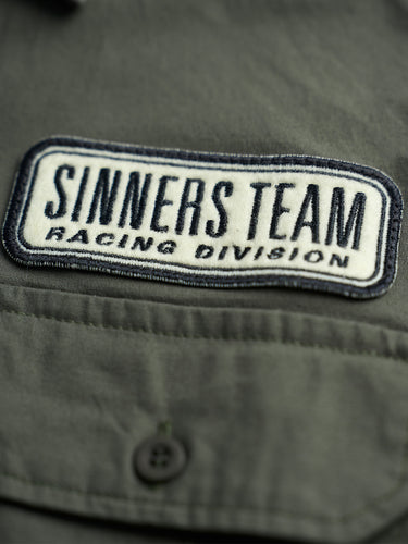 Camisa Garage Russel verde, detalle del parche bordado "Sinners Team Racing Division". #color_verde