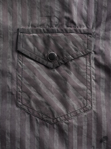 Camisa Demons & Machines confeccionada en poplin de algodón escocés con proceso de engrasado sobre prenda terminada. Broches perla negros en cartera y cuello. Bolsillos plaqué con tapa al frente.