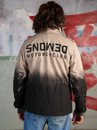 Campera de Demons & Machines, confeccionada en tela Rip Stop. De calce recto y largo a media cadera, estampa de marca con serigrafía tanto al frente como en la espalda. #color_arena