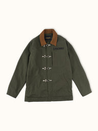 Campera confeccionada en canvas pesado de algodón, con cuello en corderoy a contratono.  Acceso frontal con cierre de metal oculto y mosquetones de metal a la vista. Este detalle está inspirado en los uniformes de los bomberos, sirven principalmente para cerrar de forma segura y rápida las prendas, garantizando que no se abran durante la emergencia, además de resistir altas temperaturas. #color_verde