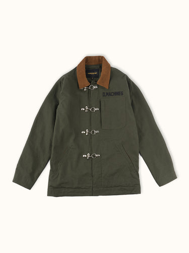 Campera confeccionada en canvas pesado de algodón, con cuello en corderoy a contratono.  Acceso frontal con cierre de metal oculto y mosquetones de metal a la vista. Este detalle está inspirado en los uniformes de los bomberos, sirven principalmente para cerrar de forma segura y rápida las prendas, garantizando que no se abran durante la emergencia, además de resistir altas temperaturas. #color_verde