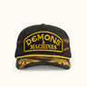 Gorra Podium de Demons & Machines en camuflaje, vista frontal mostrando el diseño y logotipo en la parte delantera.