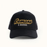 Gorra Demons & Machines estilo trucker con bordado en la frente y malla de nylon en la parte trasera. Talle único, cierre ajustable.#color_negro