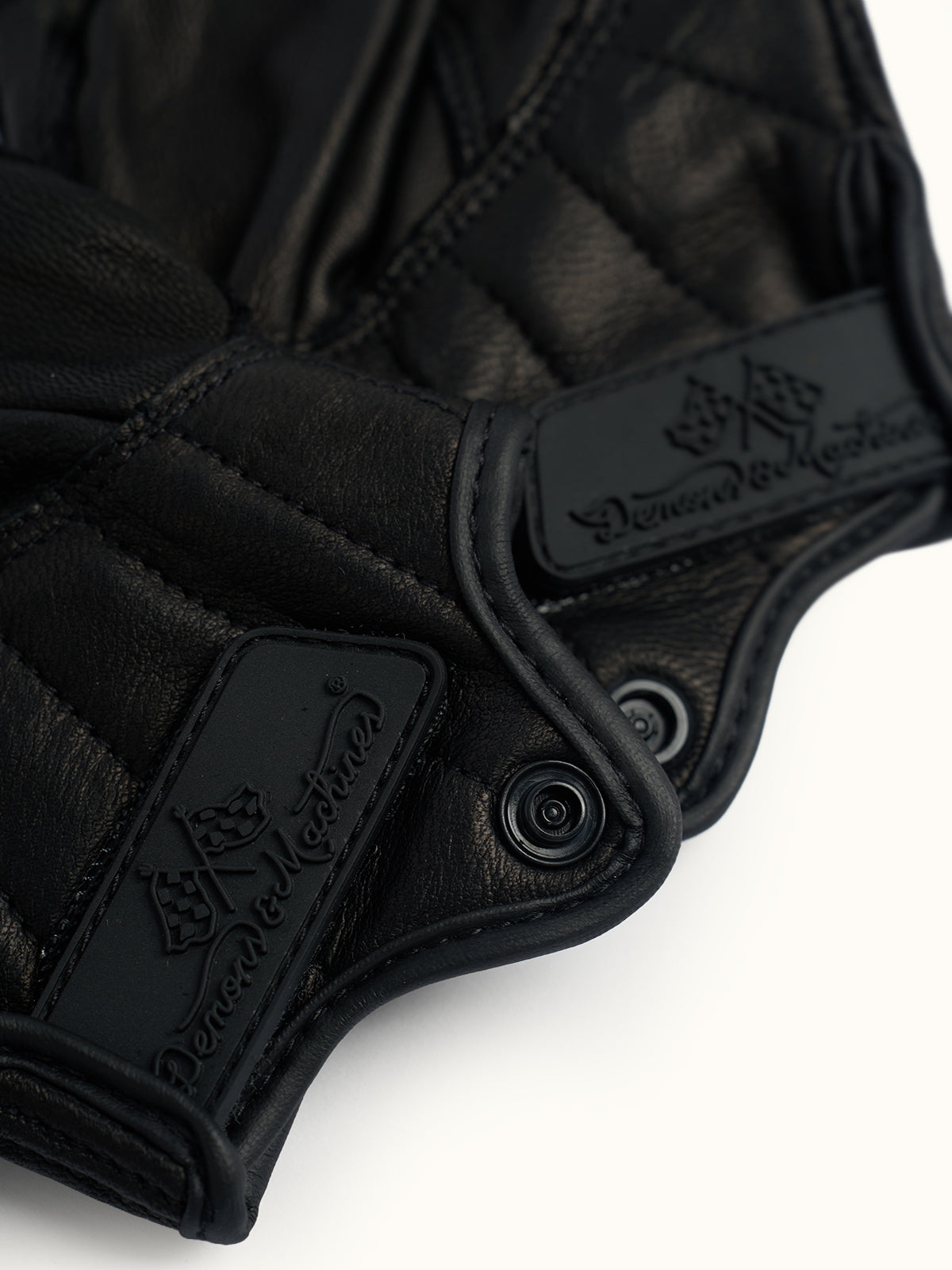Primer plano de los puños de los Guantes Redwood con abrojo, broche y logo Demons & Machines grabado