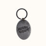 Llavero Sinclair de Demons & Machines con diseño metálico y detalles en relieve, ideal para llaves y accesorios.
