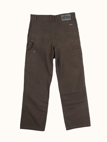 Pantalón Demons & Machines modelo carpintero confeccionado en canvas pesado de algodón. Calce relajado en cadera con una apertura de pierna recta y cómoda. Rodillas doble capa de tela, pasacintos resistentes y bolsillos traseros reforzados. Cuenta con múltiples bolsillos para herramientas y artículos diversos, además de presilla para martillo en la pierna izquierda.#color_marr-n