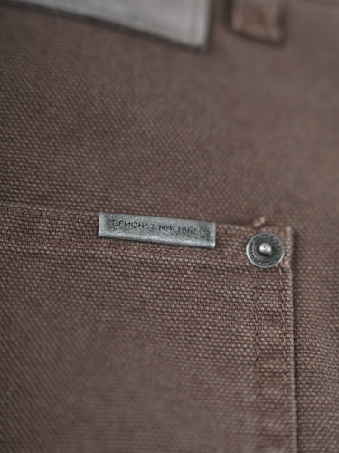 Pantalón Demons & Machines modelo carpintero confeccionado en canvas pesado de algodón. Calce relajado en cadera con una apertura de pierna recta y cómoda. Rodillas doble capa de tela, pasacintos resistentes y bolsillos traseros reforzados. Cuenta con múltiples bolsillos para herramientas y artículos diversos, además de presilla para martillo en la pierna izquierda. #color_marr-n