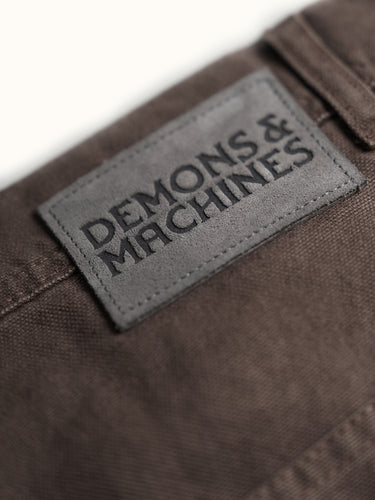 Pantalón Demons & Machines modelo carpintero confeccionado en canvas pesado de algodón. Calce relajado en cadera con una apertura de pierna recta y cómoda. Rodillas doble capa de tela, pasacintos resistentes y bolsillos traseros reforzados. Cuenta con múltiples bolsillos para herramientas y artículos diversos, además de presilla para martillo en la pierna izquierda. #color_marr-n