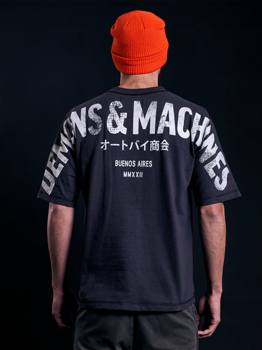 Remera Demons & Machines manga corta calce relaxed, con hombro caído, confeccionada en Jersey 16/1 de algodón peinado. Cuello aplicado con tejido ribb al tono. Terminaciones de sisas, mangas y ruedo con bordador. Estampa marcaria en espalda abarcando de manga a manga, con serigrafía en tinta al agua y efecto gastado. Suavizado sobre prenda terminada, dandole un look gastado imperfecto a la tela y a la estampa. #color_negro
