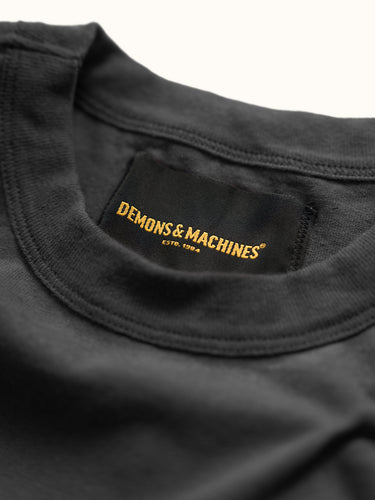Remera slim Demons & Machines, 100% algodón pesado premium, con bordado inferior de marca, tela suave y ajustada para estilo casual. #color_negro