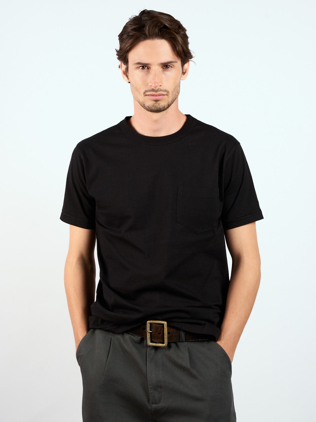 Remera Pocket Slim negra puesta, de frente con cinturón de cuero y pantalón gris #color_negro