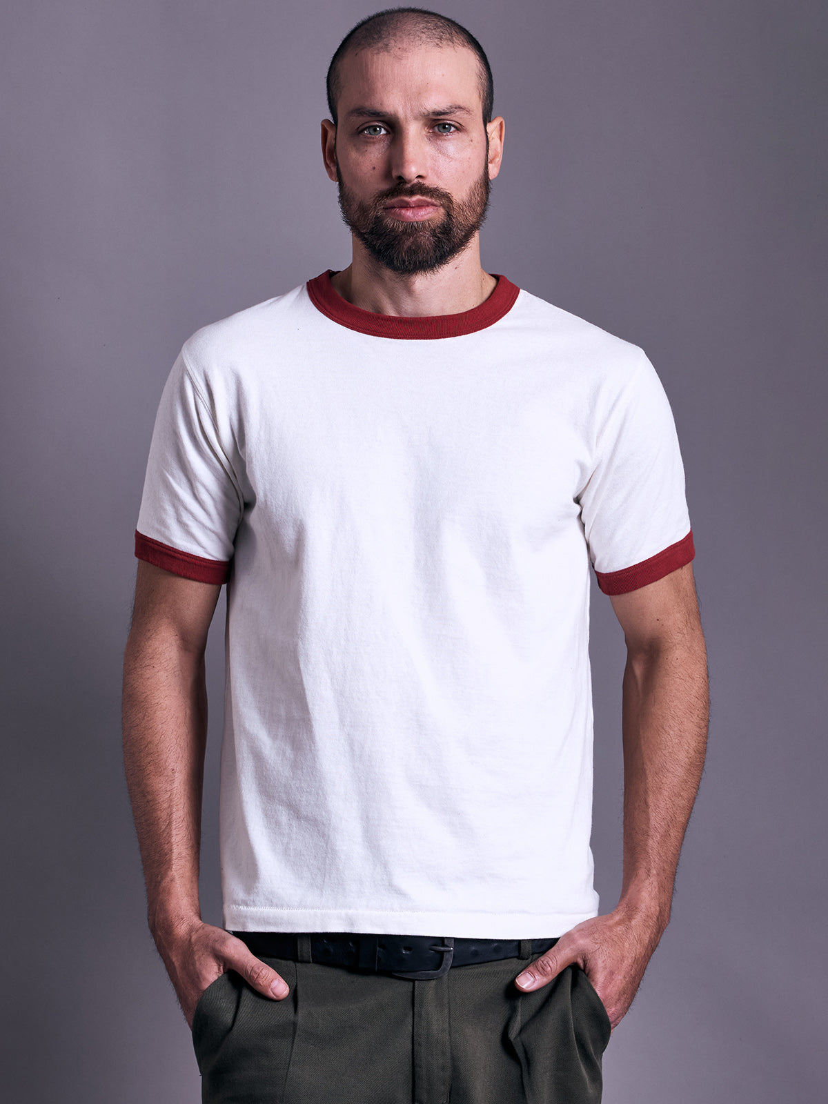 Remera Sporty Slim ladrillo puesta, de frente con cuerpo crudo, cuello y puños ladrillo y pantalón verde #color_ladrillo