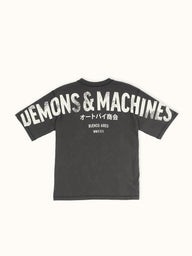 Remera Demons & Machines manga corta calce relaxed, con hombro caído, confeccionada en Jersey 16/1 de algodón peinado. Cuello aplicado con tejido ribb al tono. Terminaciones de sisas, mangas y ruedo con bordador. Estampa marcaria en espalda abarcando de manga a manga, con serigrafía en tinta al agua y efecto gastado. Suavizado sobre prenda terminada, dandole un look gastado imperfecto a la tela y a la estampa. #color_negro