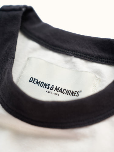 Remera deportiva Demons & Machines, 100% algodón premium con cuello y puños combinados a contra tono con diseño moderno, bordado inferior de logo y ajuste cómodo para entrenamiento. #color_negro
