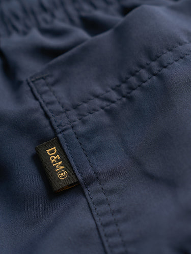 Short de baño Demons & Machines confeccionado en microfibra mate. Bolsillos laterales, cintura elastizada con cordón ajustable y logo bordado al tono. #color_azul
