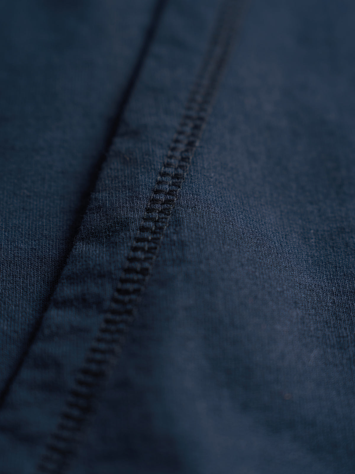 Primer plano de la costura de la sisa sin mangas en el tejido del Training Hood Vest azul