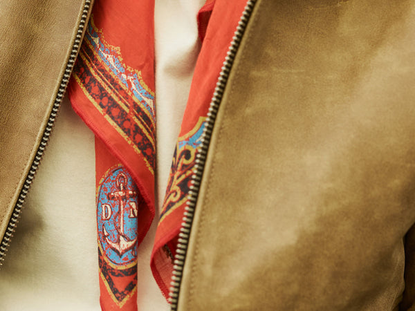 Bandana roja estampada con ancla sobre campera de cuero marrón