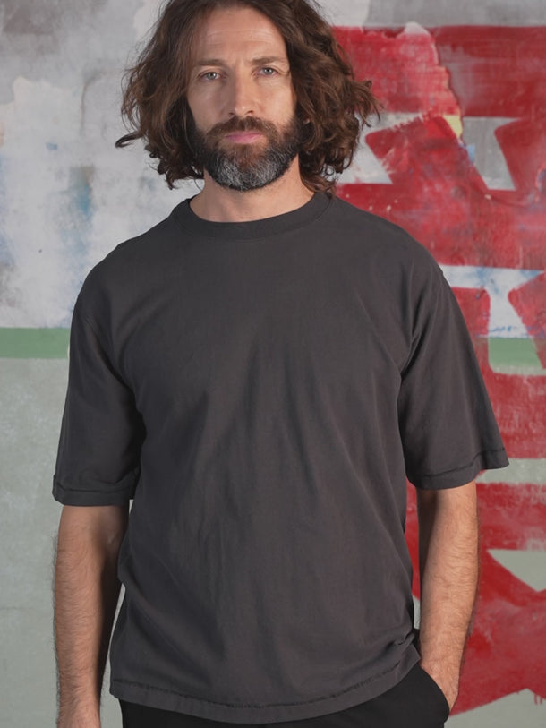 Relax T-Shirt in Black, side view — a relaxed fit with dropped shoulders. #color_black