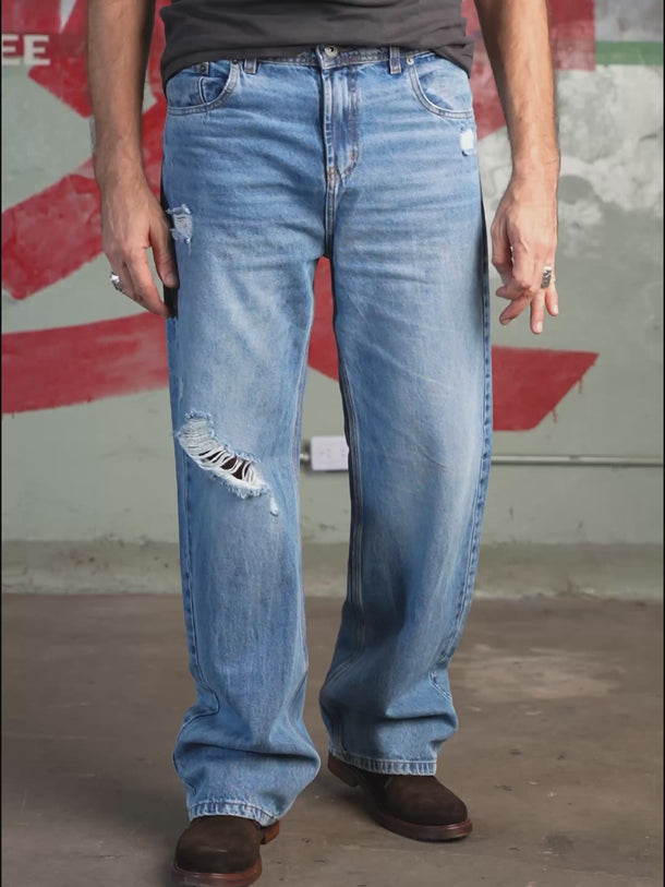 Jean de Demons & Machines de calce relaxed confeccionado en denim rígido. Este fit se caracteriza por su corte relajado, de tiro medio-bajo cae con gran amplitud desde la parte trasera hacia las piernas, terminando en una botamanga bien ancha, logrando comodidad y libertad de movimiento. Lavado destroyed en tono celeste con reservas de color azul original y roturas localizadas a lo largo del frente.