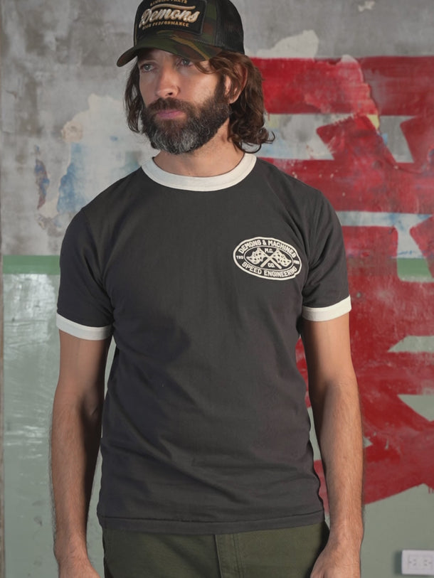 Remera deportiva Demons & Machines Speed, 100% algodón premium con cuello y puños combinados a contra tono con diseño moderno, estampa puff y ajuste cómodo para entrenamiento. #color_negro